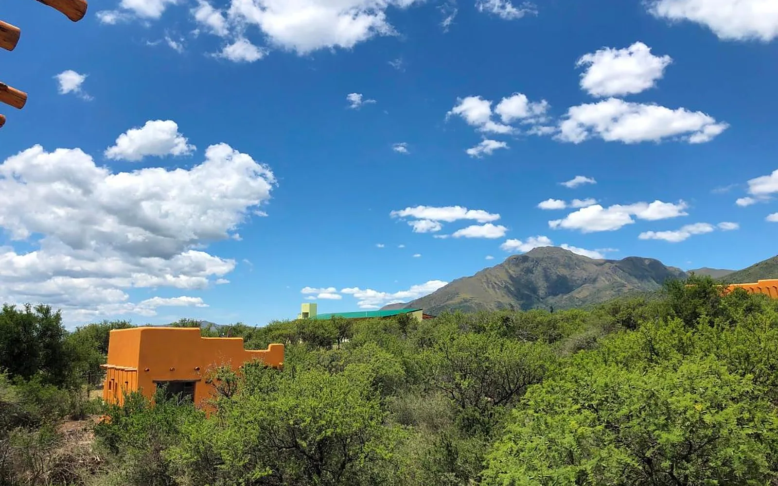 Las casitas de adobe de Taos Pueblo entre el monte, con el cerro Uritorco de fondo, en Capilla del Monte